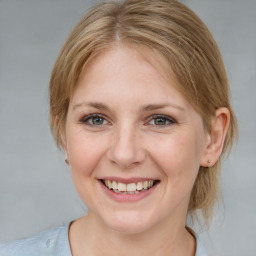 Joyful white young-adult female with medium  brown hair and blue eyes