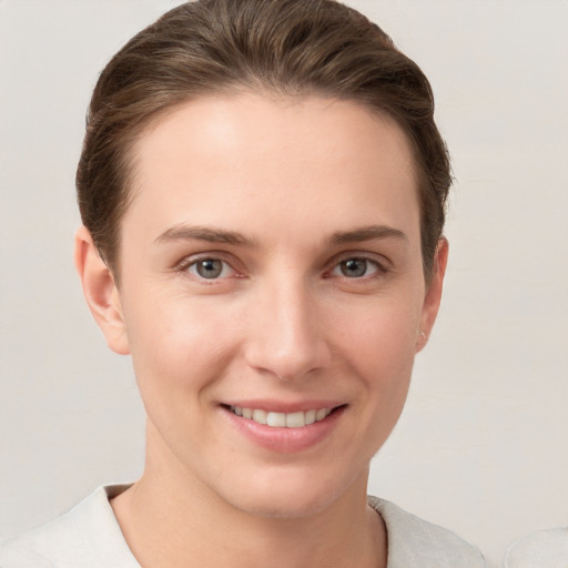 Joyful white young-adult female with short  brown hair and grey eyes