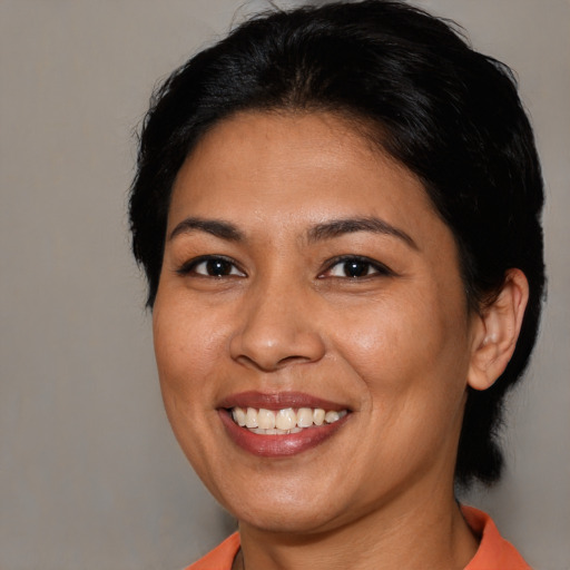 Joyful latino adult female with medium  black hair and brown eyes