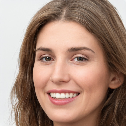 Joyful white young-adult female with long  brown hair and green eyes