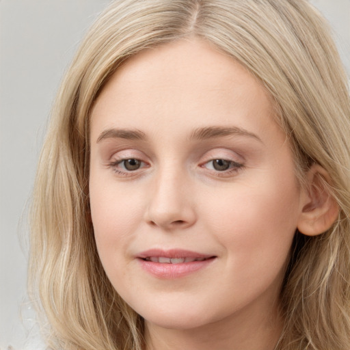 Joyful white young-adult female with long  brown hair and blue eyes