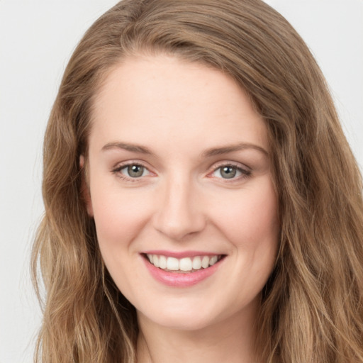 Joyful white young-adult female with long  brown hair and blue eyes