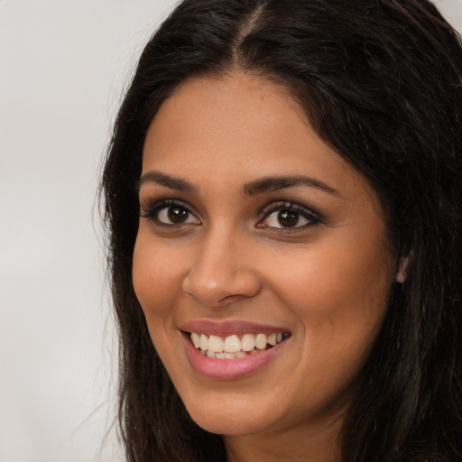 Joyful latino young-adult female with long  brown hair and brown eyes