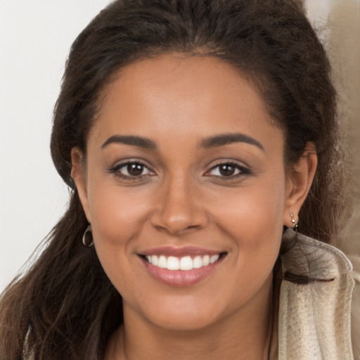 Joyful latino young-adult female with long  brown hair and brown eyes