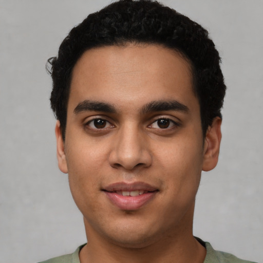 Joyful latino young-adult male with short  black hair and brown eyes