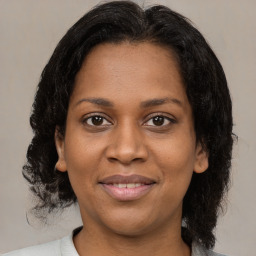 Joyful black adult female with medium  brown hair and brown eyes