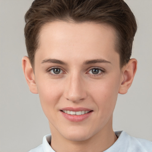 Joyful white young-adult female with short  brown hair and grey eyes