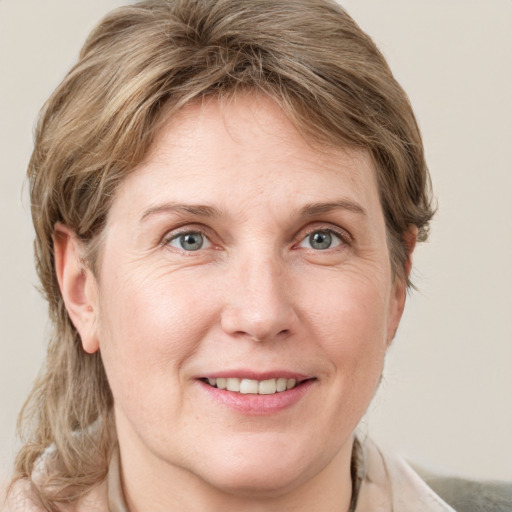 Joyful white adult female with medium  brown hair and grey eyes