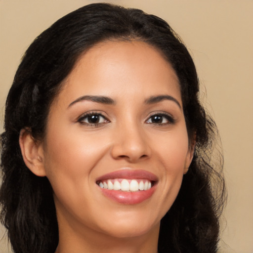 Joyful latino young-adult female with long  brown hair and brown eyes