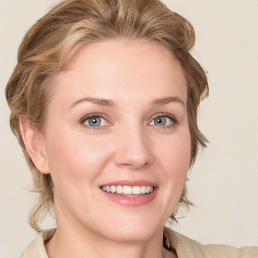 Joyful white young-adult female with medium  brown hair and blue eyes