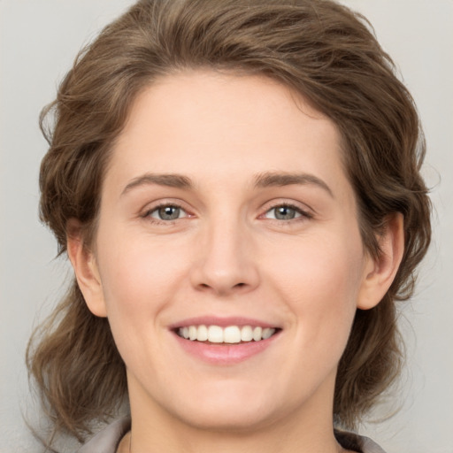 Joyful white young-adult female with medium  brown hair and green eyes