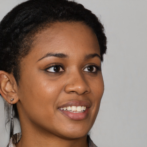 Joyful black young-adult female with long  brown hair and brown eyes
