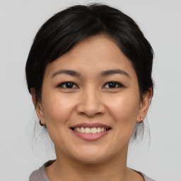 Joyful asian young-adult female with medium  brown hair and brown eyes