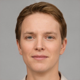 Joyful white young-adult male with short  brown hair and grey eyes