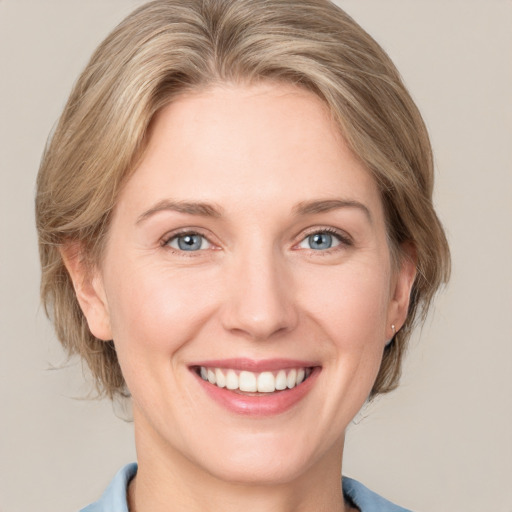 Joyful white adult female with medium  brown hair and blue eyes