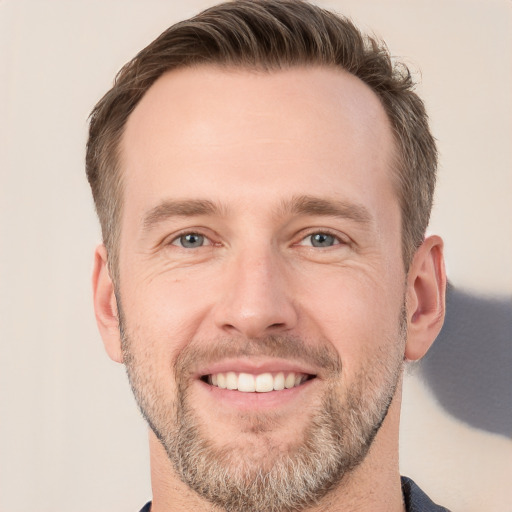 Joyful white adult male with short  brown hair and grey eyes