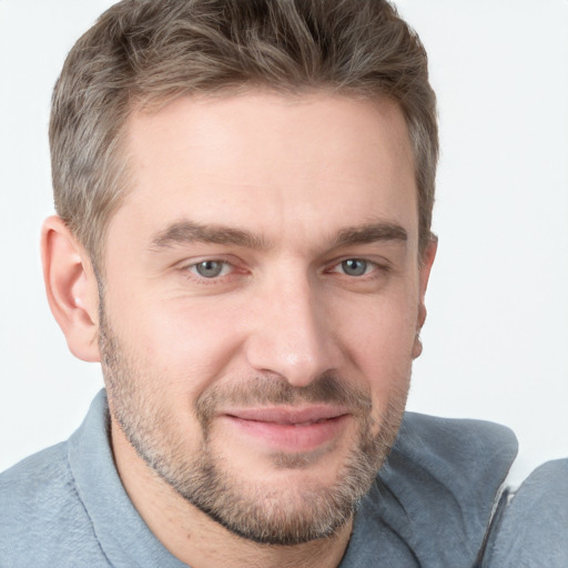 Joyful white young-adult male with short  brown hair and grey eyes