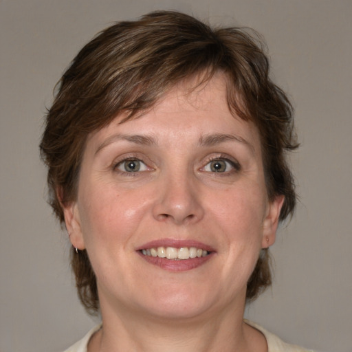 Joyful white adult female with medium  brown hair and blue eyes