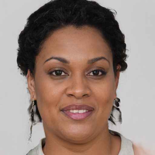 Joyful black adult female with short  brown hair and brown eyes