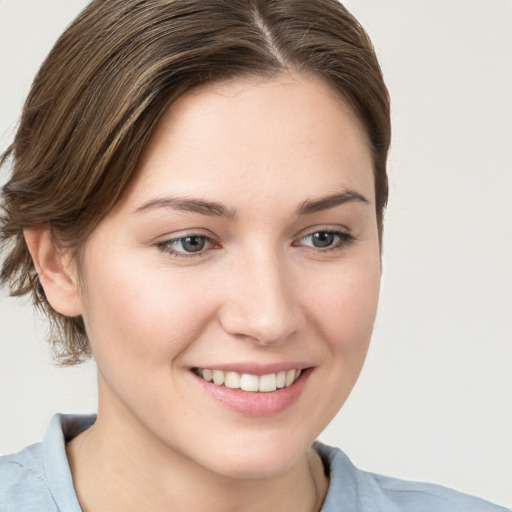 Joyful white young-adult female with medium  brown hair and blue eyes