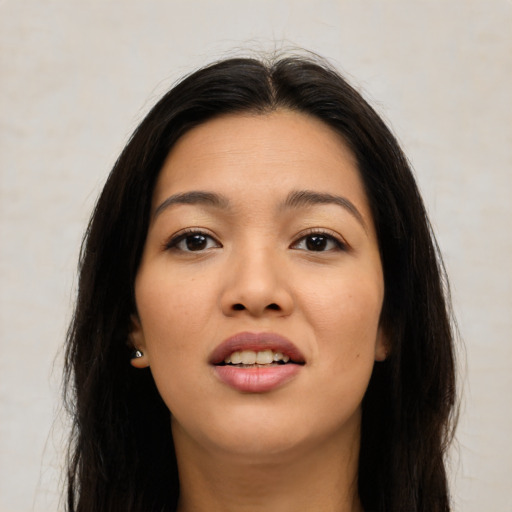 Joyful latino young-adult female with long  black hair and brown eyes