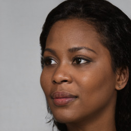 Joyful black young-adult female with long  brown hair and brown eyes