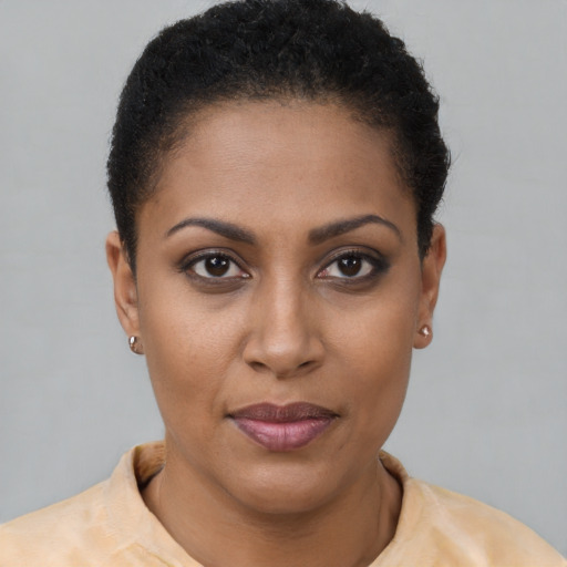 Joyful black young-adult female with short  brown hair and brown eyes