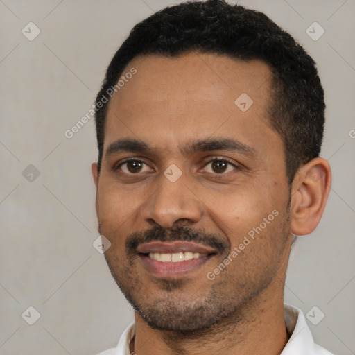 Joyful black young-adult male with short  black hair and brown eyes