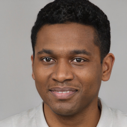 Joyful black young-adult male with short  black hair and brown eyes