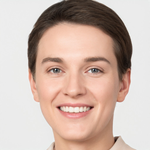 Joyful white young-adult male with short  brown hair and grey eyes