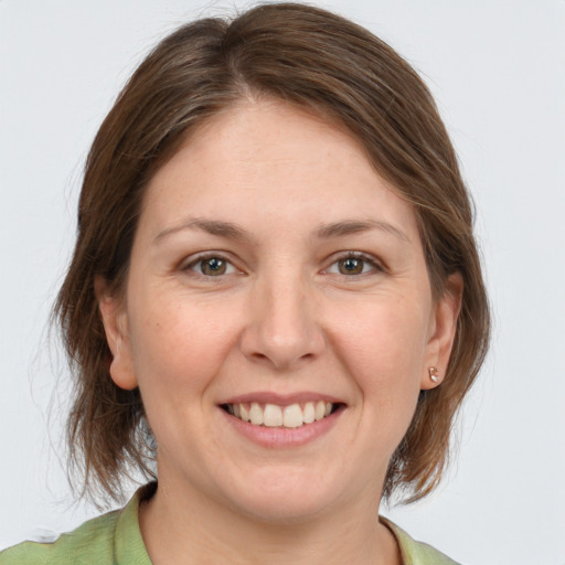 Joyful white young-adult female with medium  brown hair and grey eyes