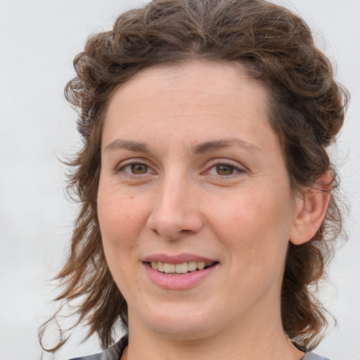 Joyful white young-adult female with medium  brown hair and green eyes