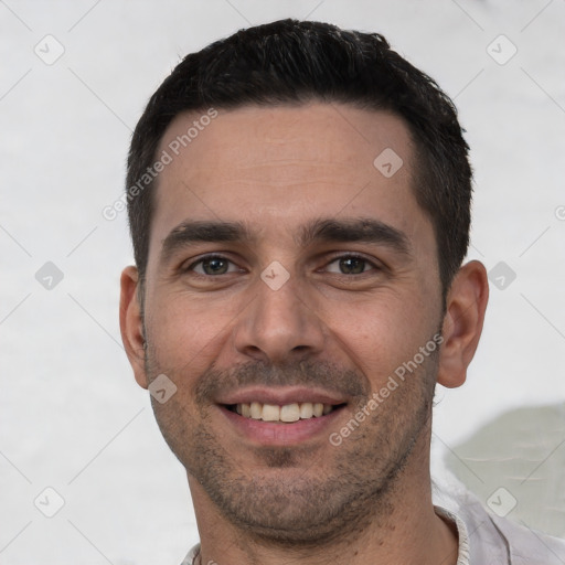 Joyful white young-adult male with short  black hair and brown eyes