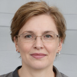 Joyful white adult female with medium  brown hair and blue eyes