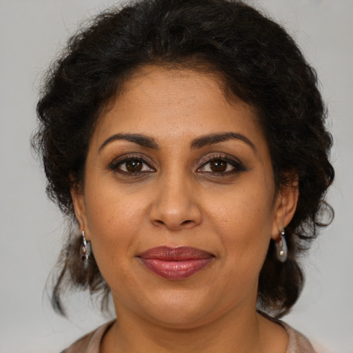 Joyful latino adult female with medium  brown hair and brown eyes