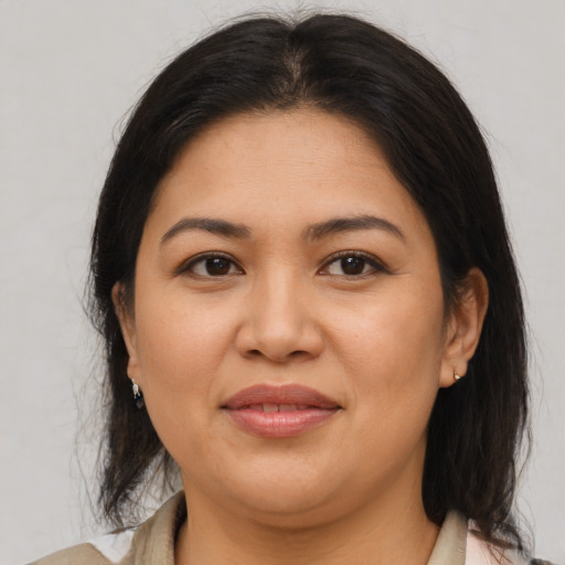 Joyful latino adult female with medium  brown hair and brown eyes