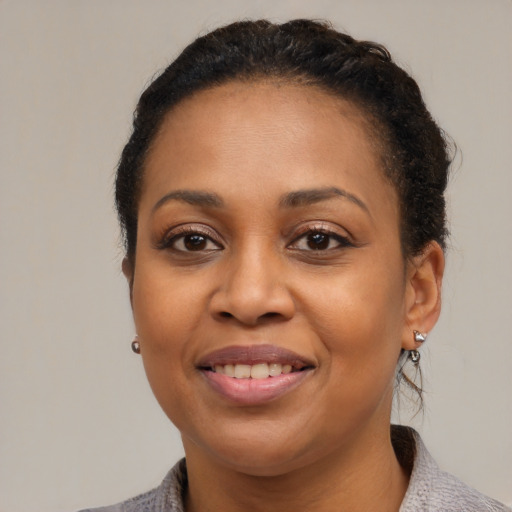 Joyful black adult female with medium  brown hair and brown eyes