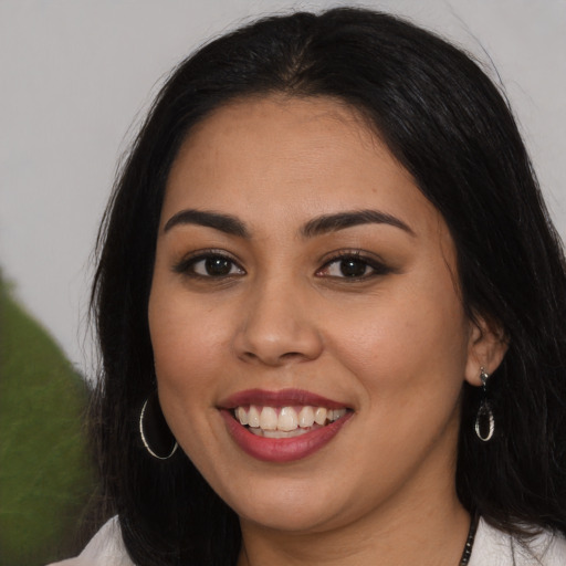 Joyful latino young-adult female with long  brown hair and brown eyes
