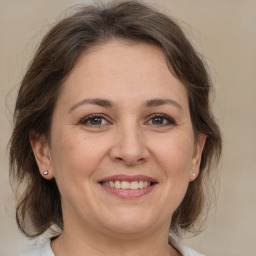 Joyful white adult female with medium  brown hair and brown eyes