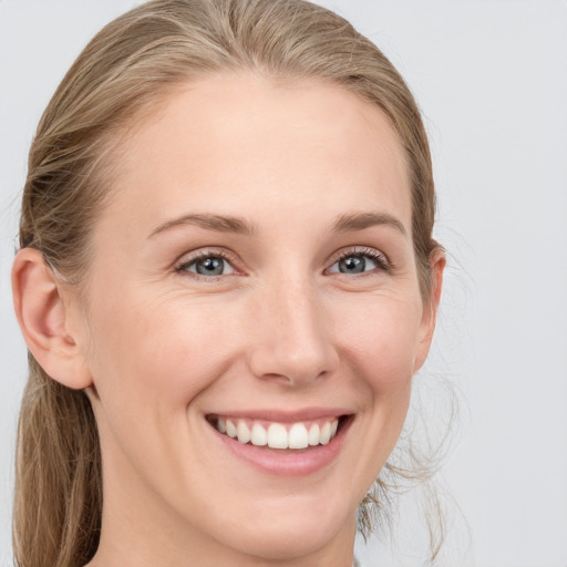 Joyful white young-adult female with medium  brown hair and blue eyes