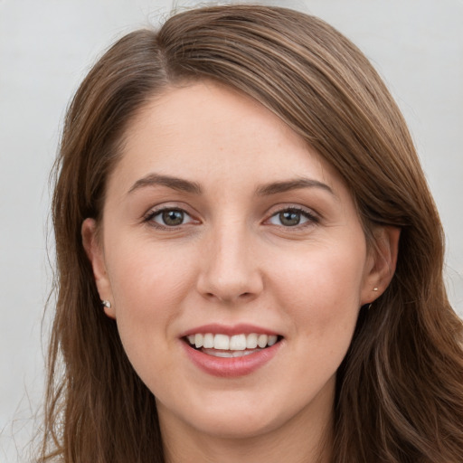 Joyful white young-adult female with long  brown hair and grey eyes