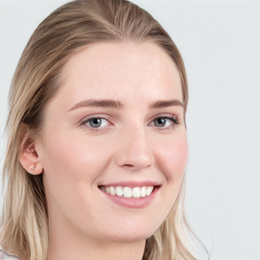 Joyful white young-adult female with long  brown hair and blue eyes