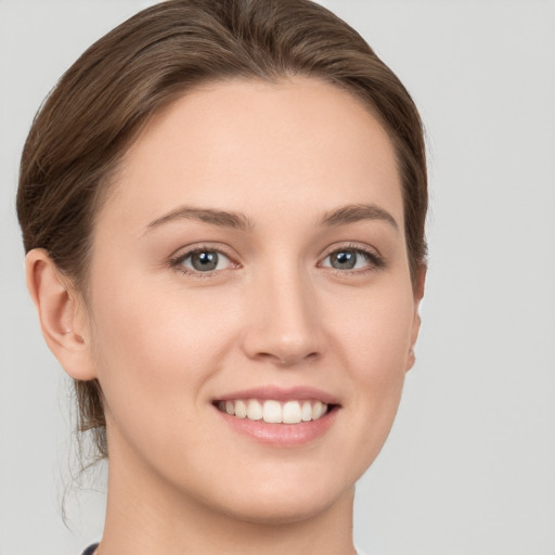 Joyful white young-adult female with short  brown hair and grey eyes