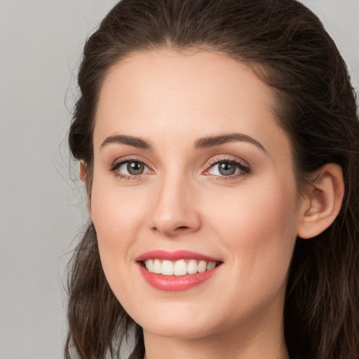 Joyful white young-adult female with long  brown hair and grey eyes