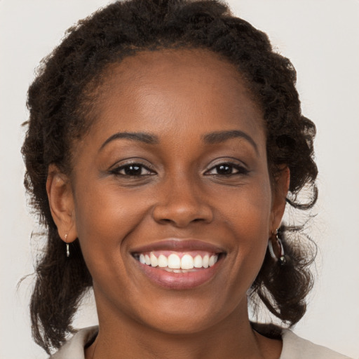 Joyful black young-adult female with medium  brown hair and brown eyes