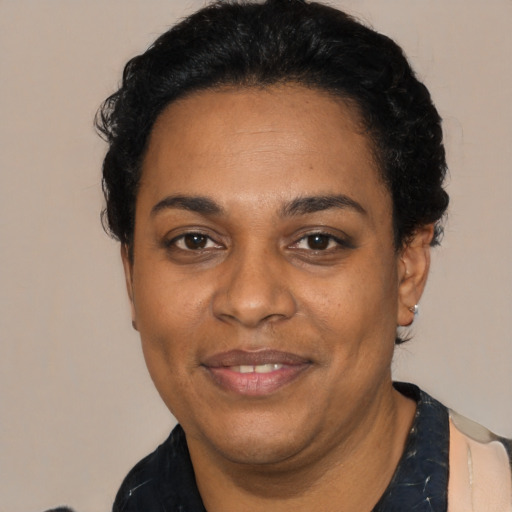Joyful black adult female with short  black hair and brown eyes