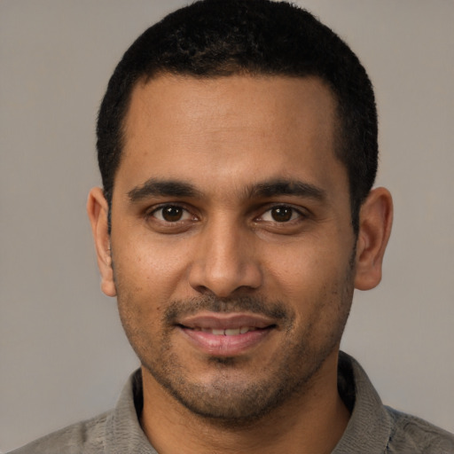 Joyful latino young-adult male with short  black hair and brown eyes