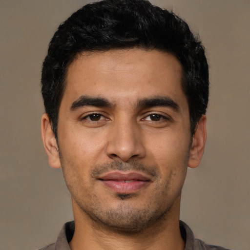 Joyful latino young-adult male with short  black hair and brown eyes