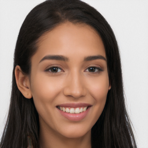 Joyful latino young-adult female with long  brown hair and brown eyes