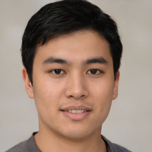 Joyful asian young-adult male with short  black hair and brown eyes